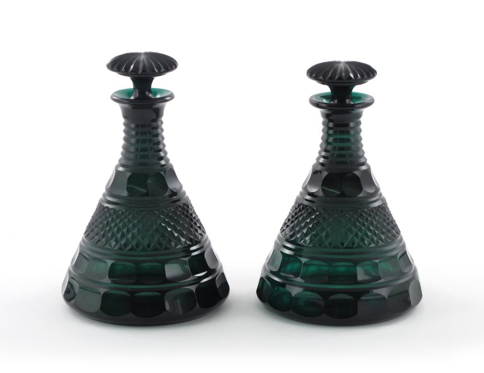 A pair of green glass ship`s decanters and stoppers, the wide-bottomed forms cut with bands of