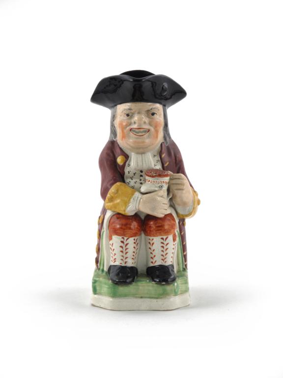 A pearlware Toby jug 1st half 19th century, typically moulded in frock coat and breeches, the