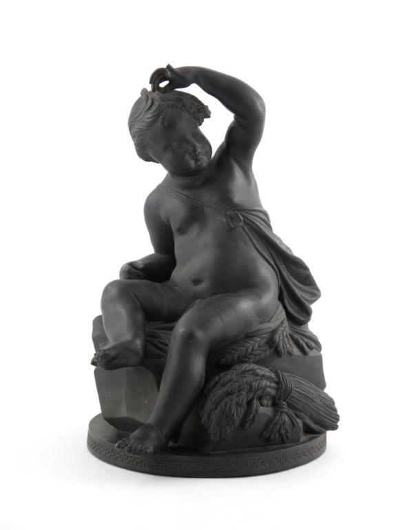 A massive black basalt model of a putto 19th century, possibly personifying Summer, semi-reclining