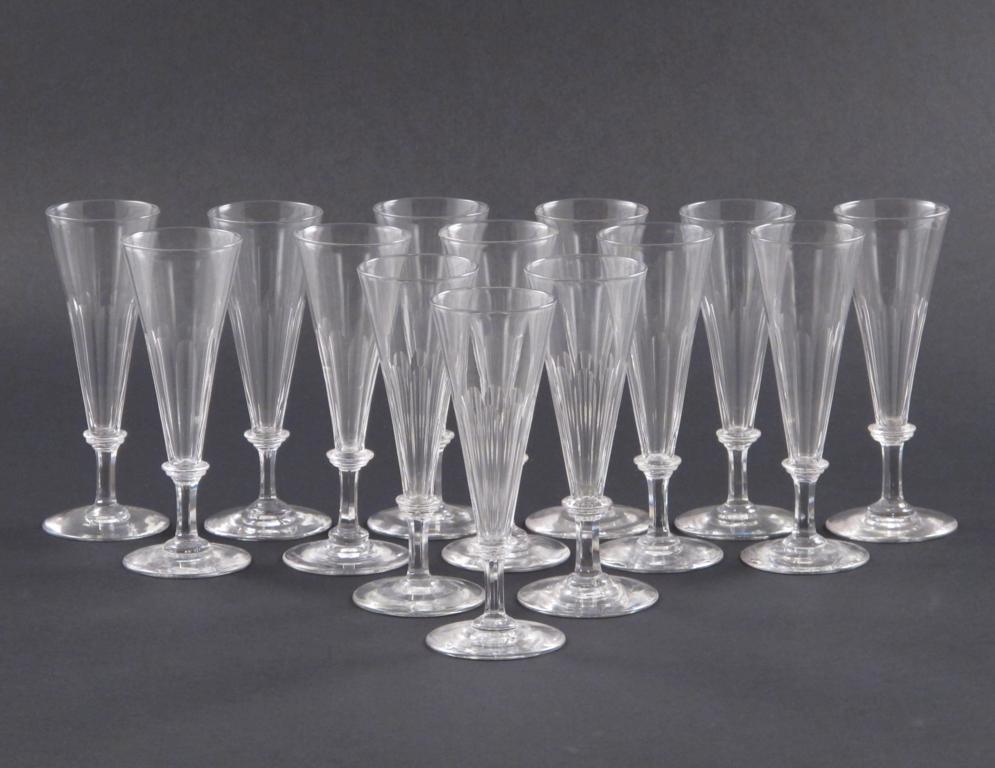 A set of 14 champagne flutes 19th century, raised on low faceted stems, the flared bowls with cut