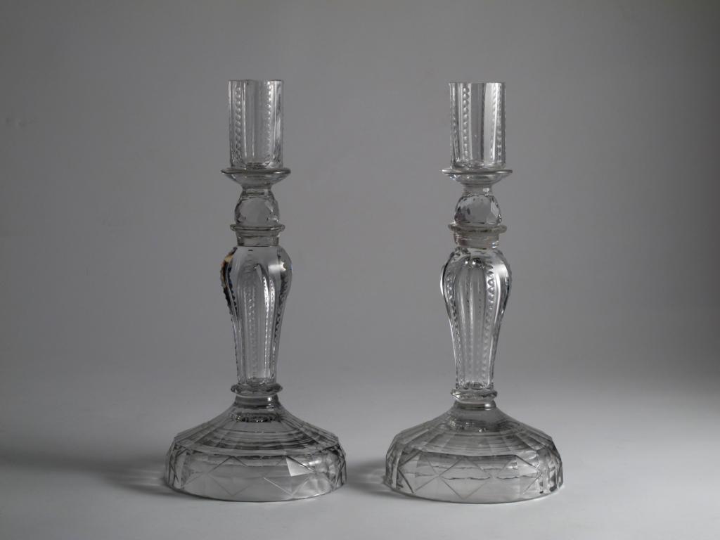 A large pair of glass candlesticks 19th century, the stems hollow and decorated with rows of