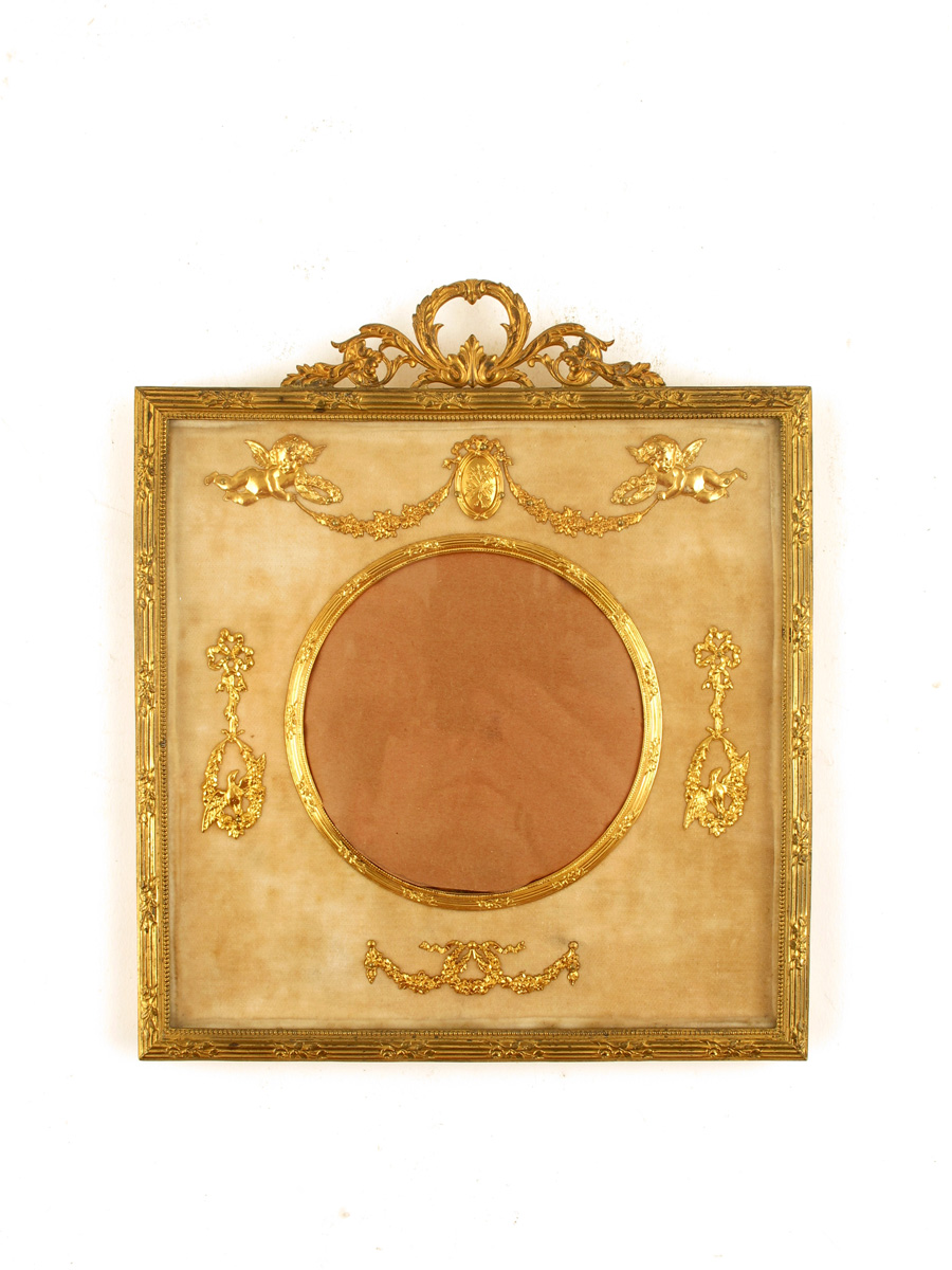 A gilt metal picture frame, with a plush mount and a circular aperture, late 19th / early 20th