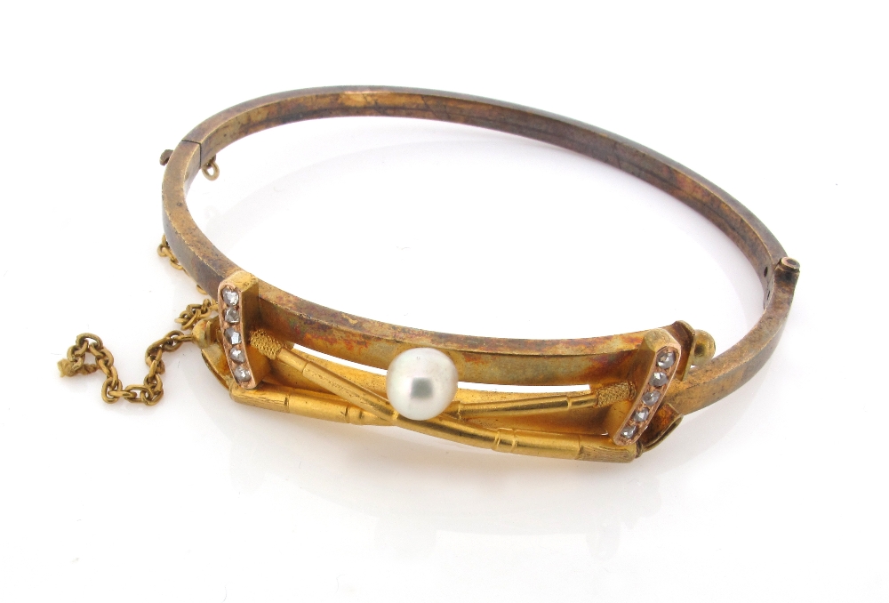 Of polo interest, a gold bangle mounted with two polo sticks with diamond set heads and an untested