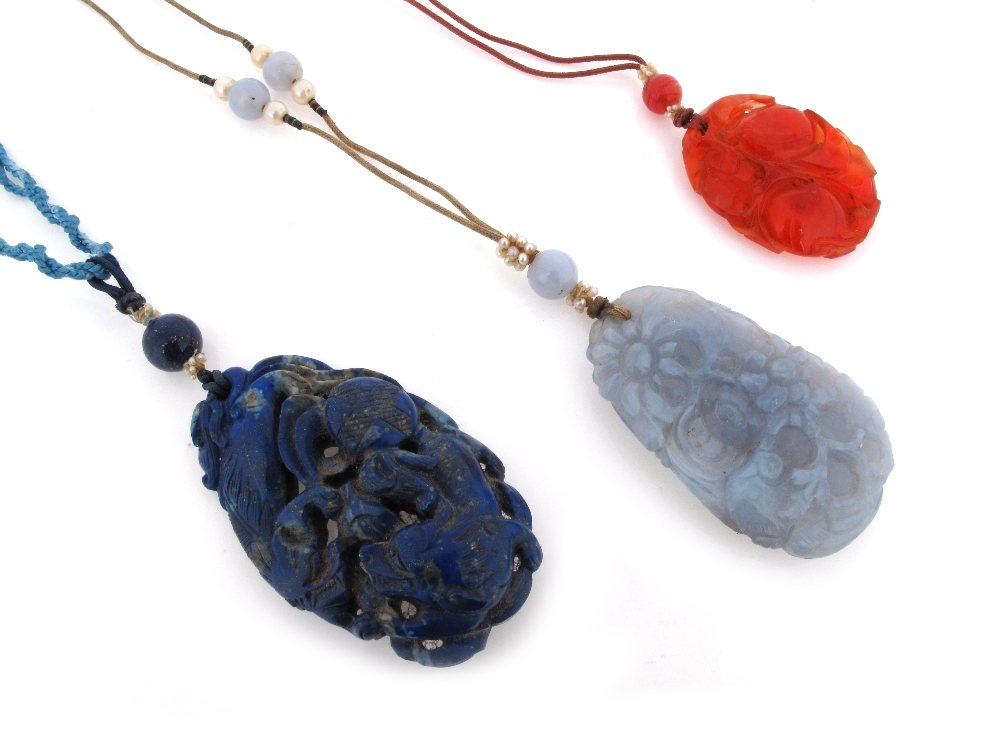 A carved lapis lazuli pendant, suspended from a lapis lazuli bead and damaged seed pearls. A carved