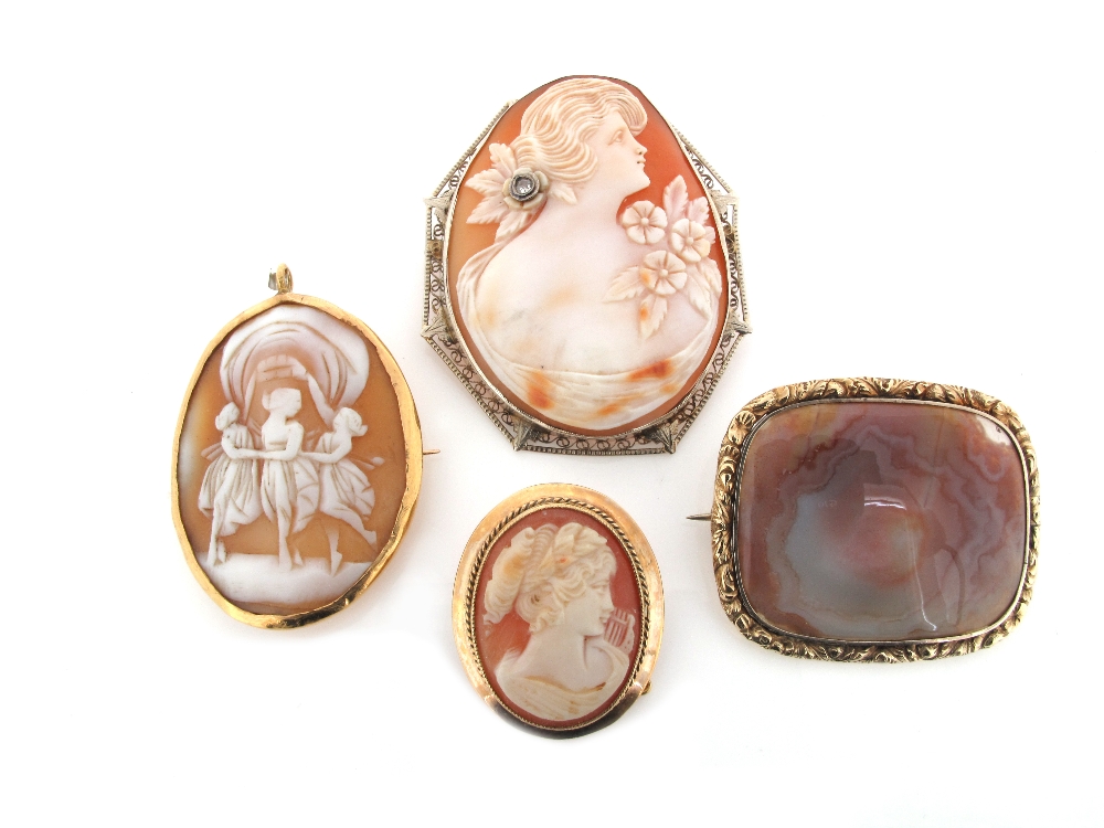 A Regency brooch mounted with jasper in a foliate frame, and three carved shell cameo brooches with