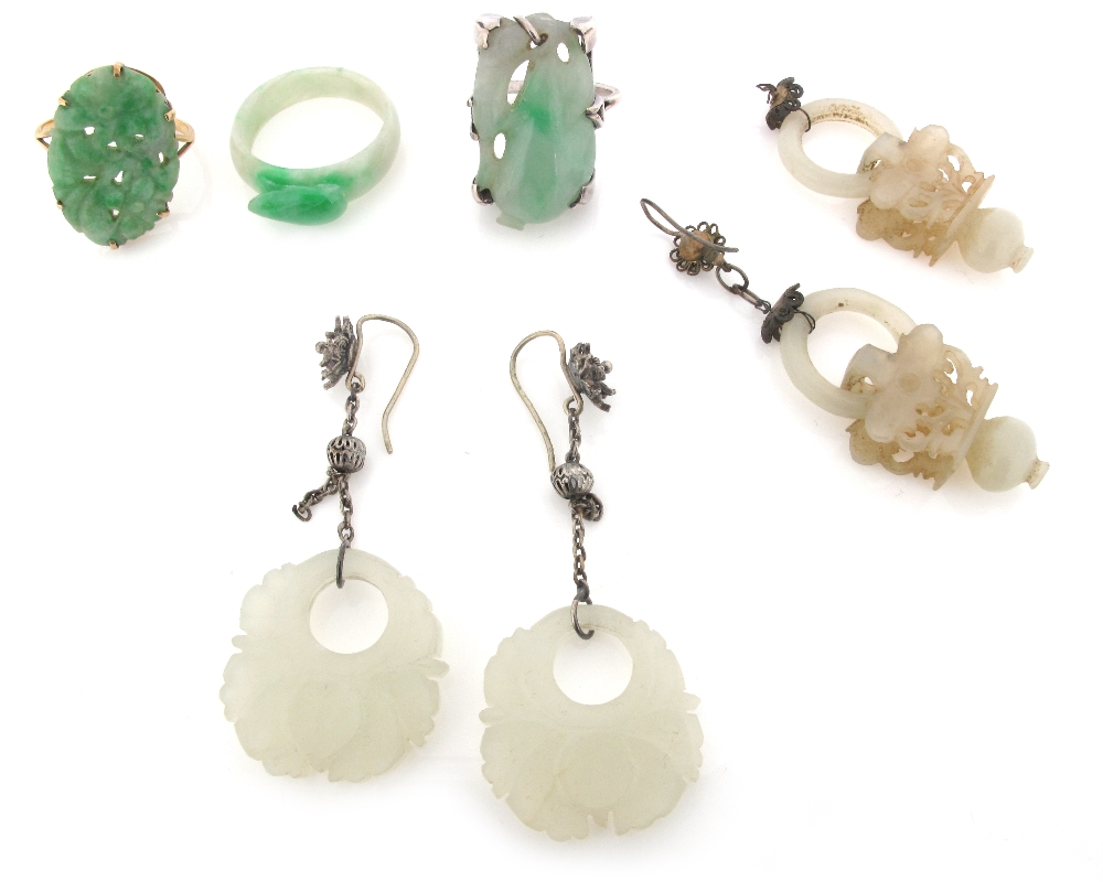 A pair of carved jade drop earrings suspending from silver mounts, a jade saddle ring, two pierced