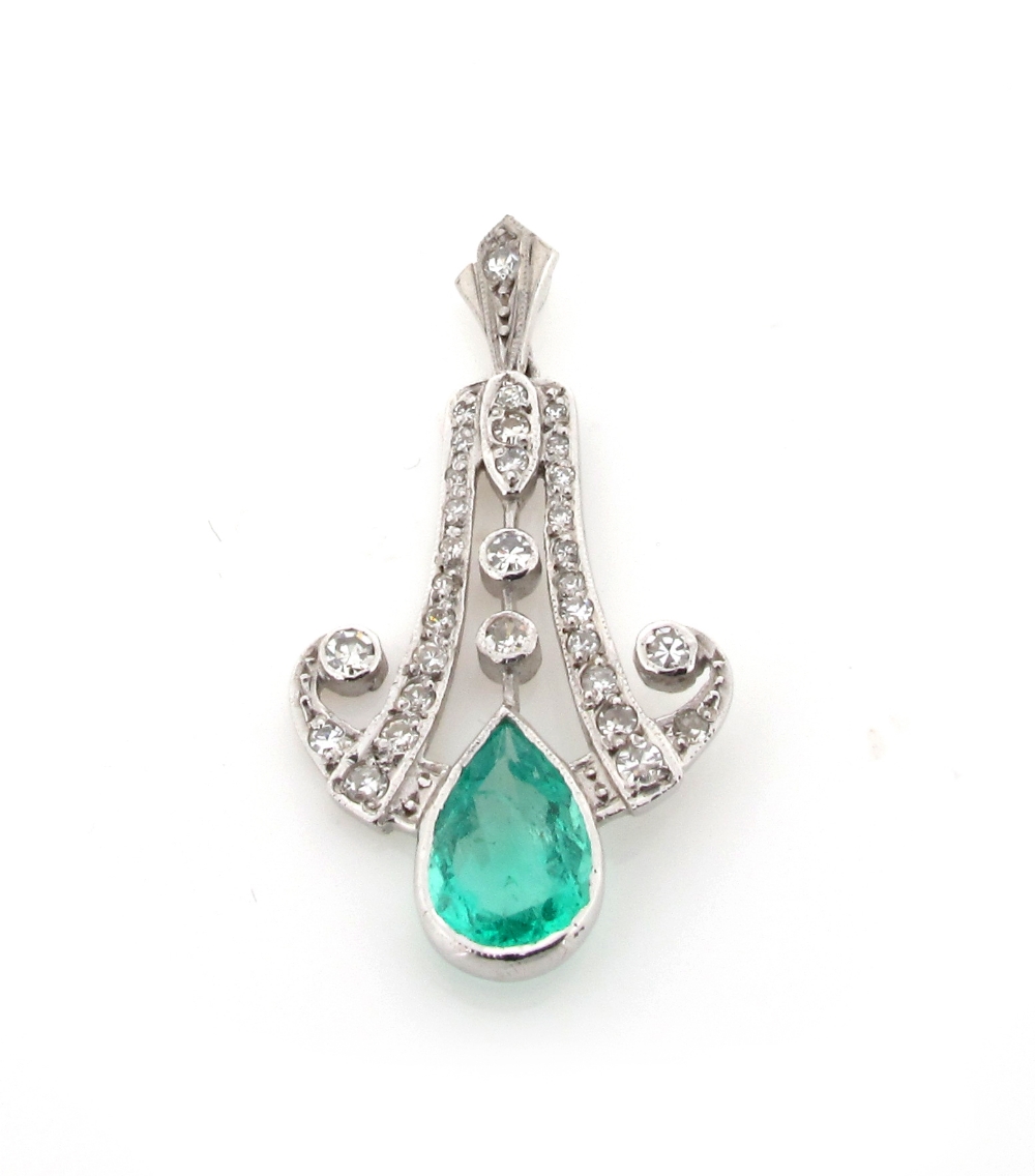 An emerald and diamond pendant, the pear shaped emerald suspends from graduated diamonds millegrain