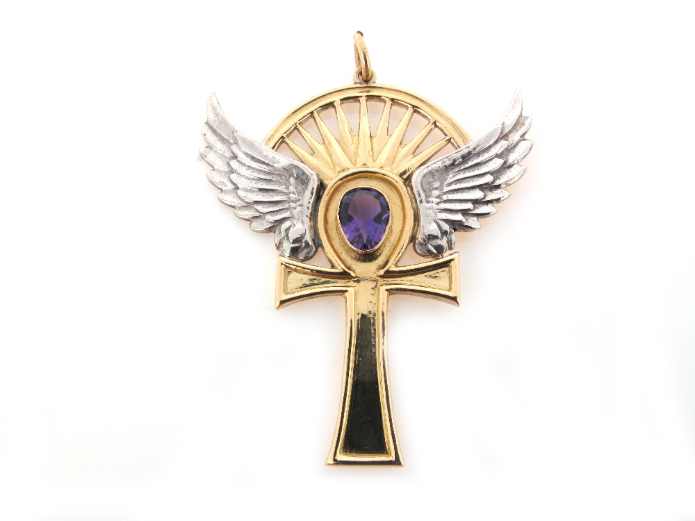 A yellow and white gold winged cross pendant, set with an amethyst. 5.5cm high.