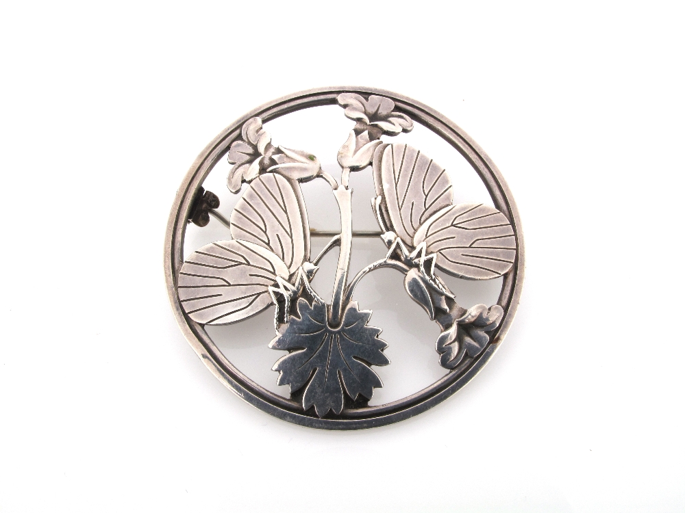 A silver brooch by Georg Jensen, the circular brooch pierced with butterflies and foliage. 283.