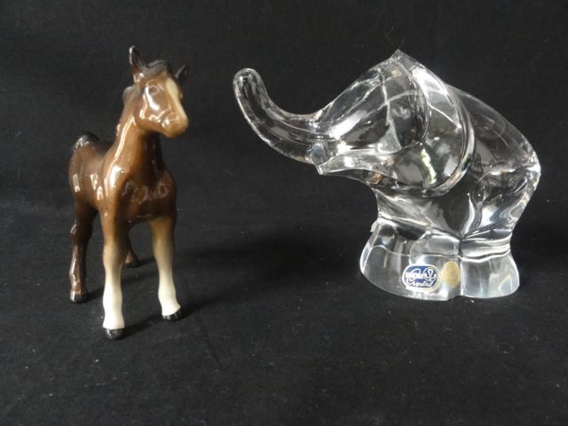 A Bohemian Crystal glass paperweight in the form of a stylised elephant together with a brown