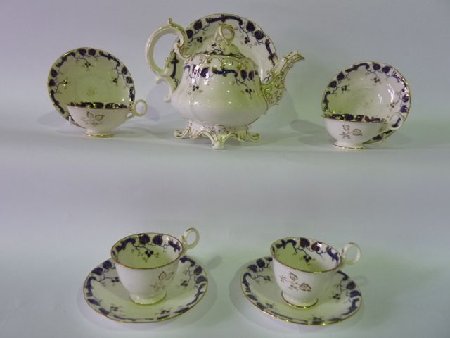 A collection of mid-19th century tea wares with blue and gilt trailing leaf border decoration