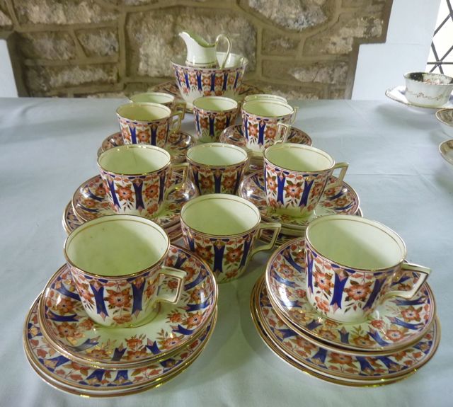 A collection of late 19th century tea wares with blue, red and gilt floral border decoration