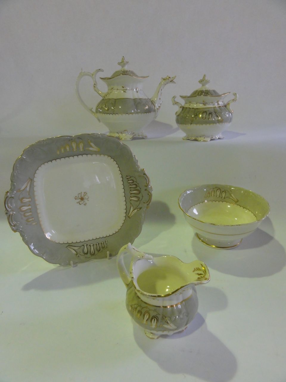 A quantity of Rococo style tea wares attributed to Coalport circa 1831 in grey and white with gilded