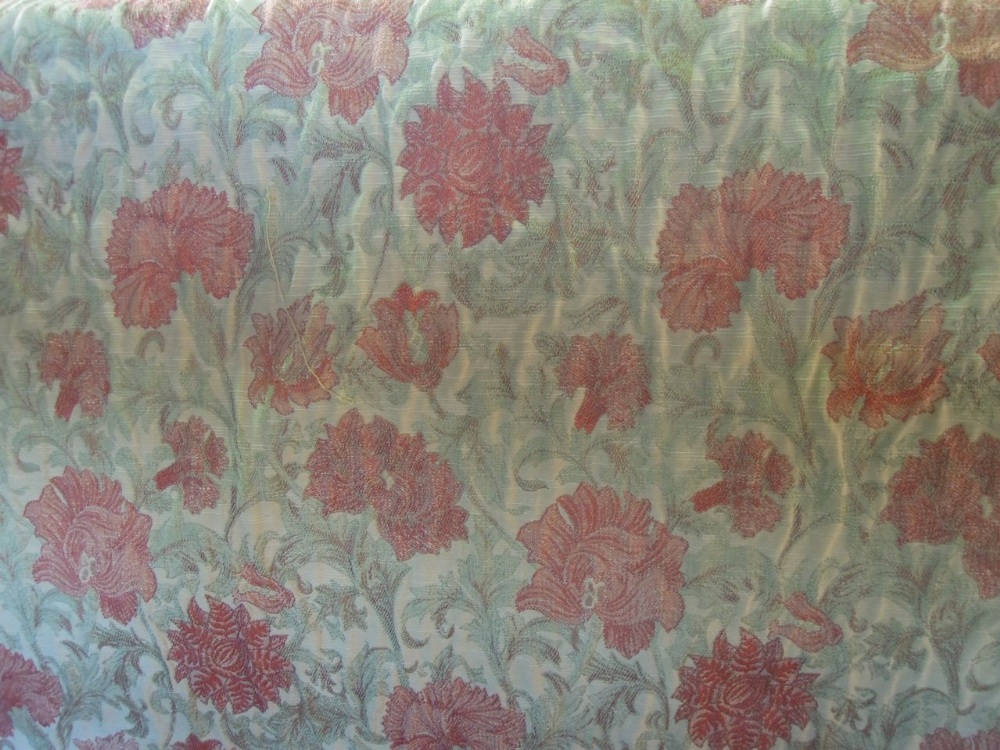 Three pairs of lined curtains in a salmon coloured floral fabric on a cream coloured background