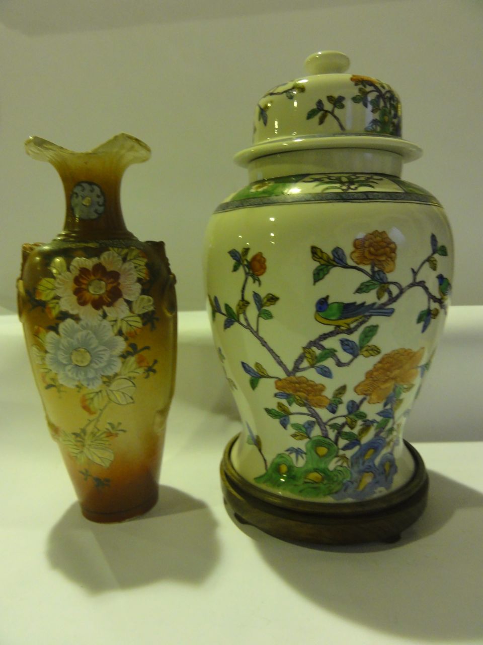 A large reproduction oriental baluster shaped lidded vase on hardwood stand decorated with birds