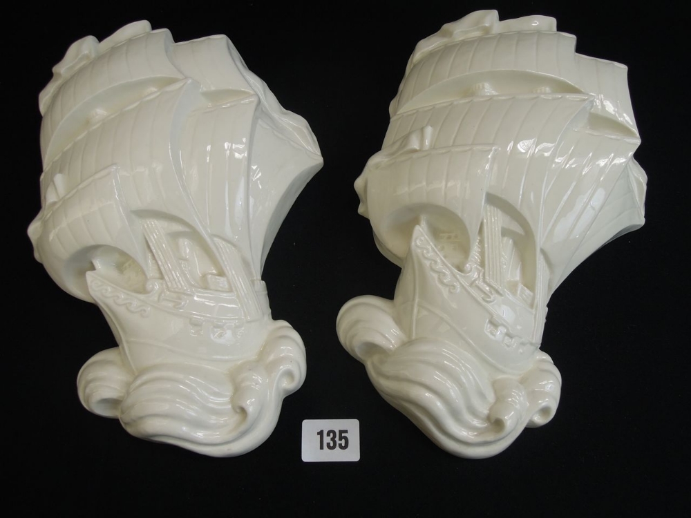 A pair of Wedgwood cream glazed galleon wall plaques, 27cm long approx with brown transfer printed