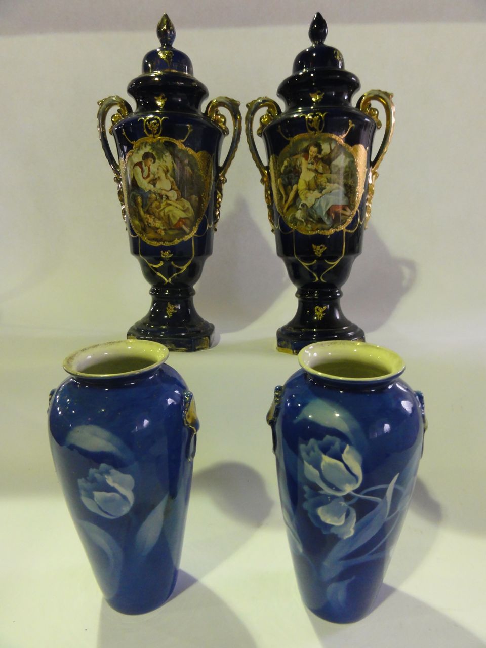 A large pair of Edwardian two handled lidded vases decorated with vignettes of romantic couples on a