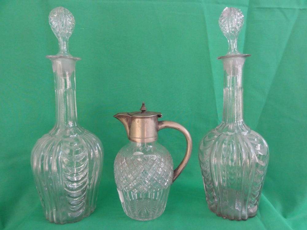 A pair of 19th century hand-blown decanters with scrolling decoration and hollow stoppers together