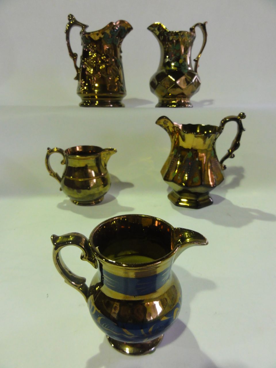 A graduated set of five copper lustre jugs including Allerton`s, Longton England