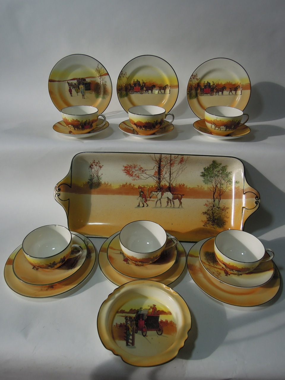 A quantity of Royal Doulton coaching days series ware comprising six trios, shallow bowl and a two