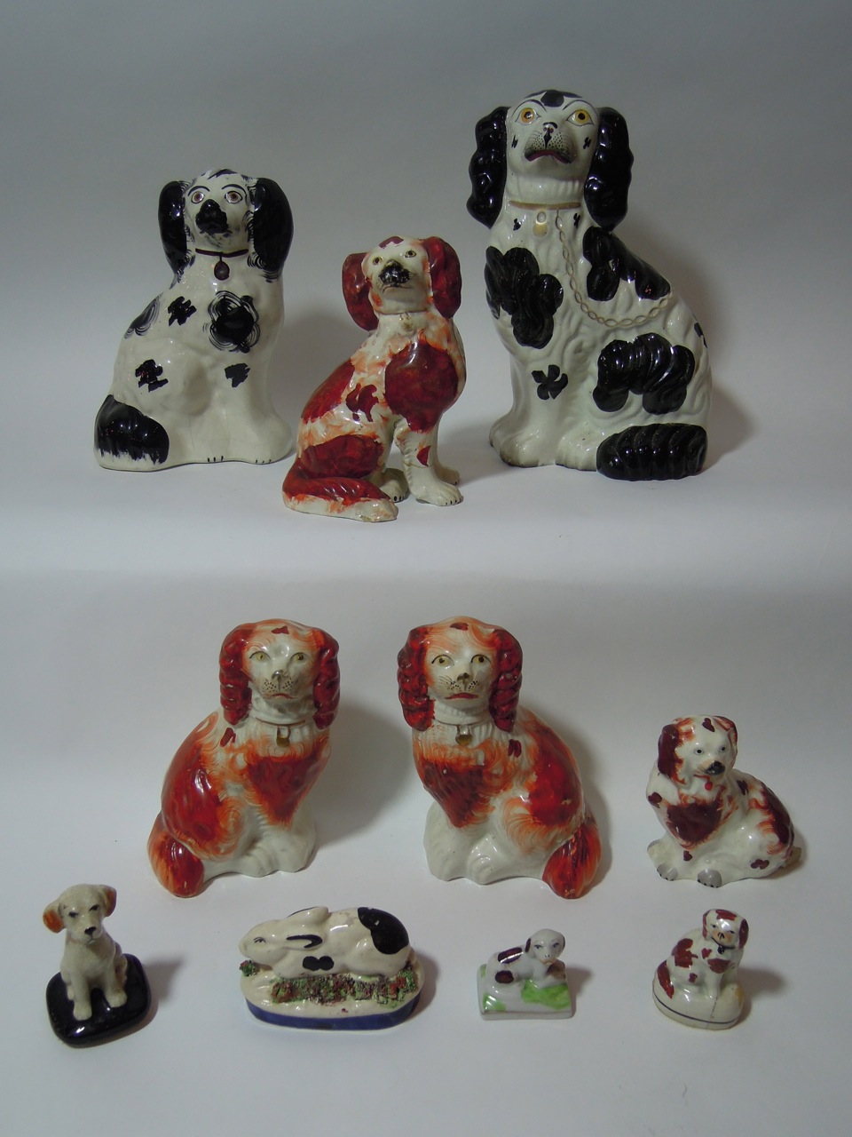 A selection of nine 19th century and later Staffordshire and other spaniels in russet and white,