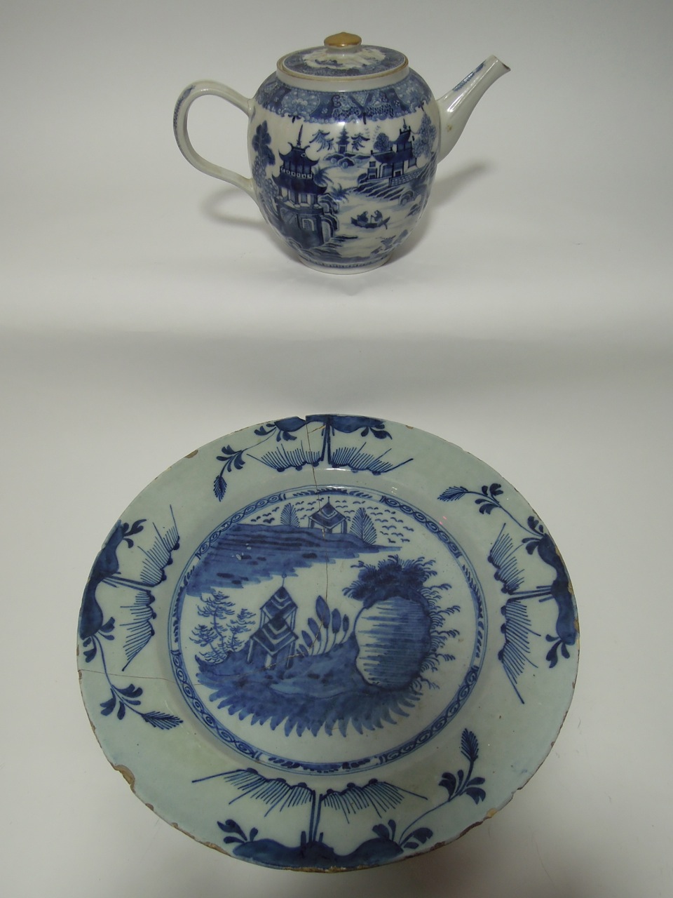 A blue and white tin glazed earthenware charger, possibly Dutch, decorated with a landscape scene