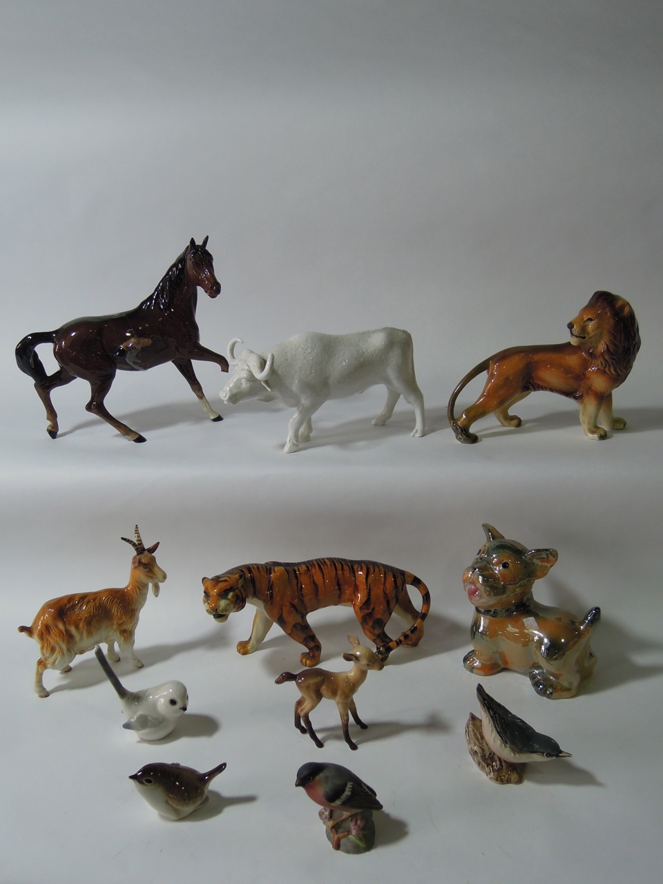 A collection of animals including a brown Beswick horse, a Western Germany lion, a Beswick goat