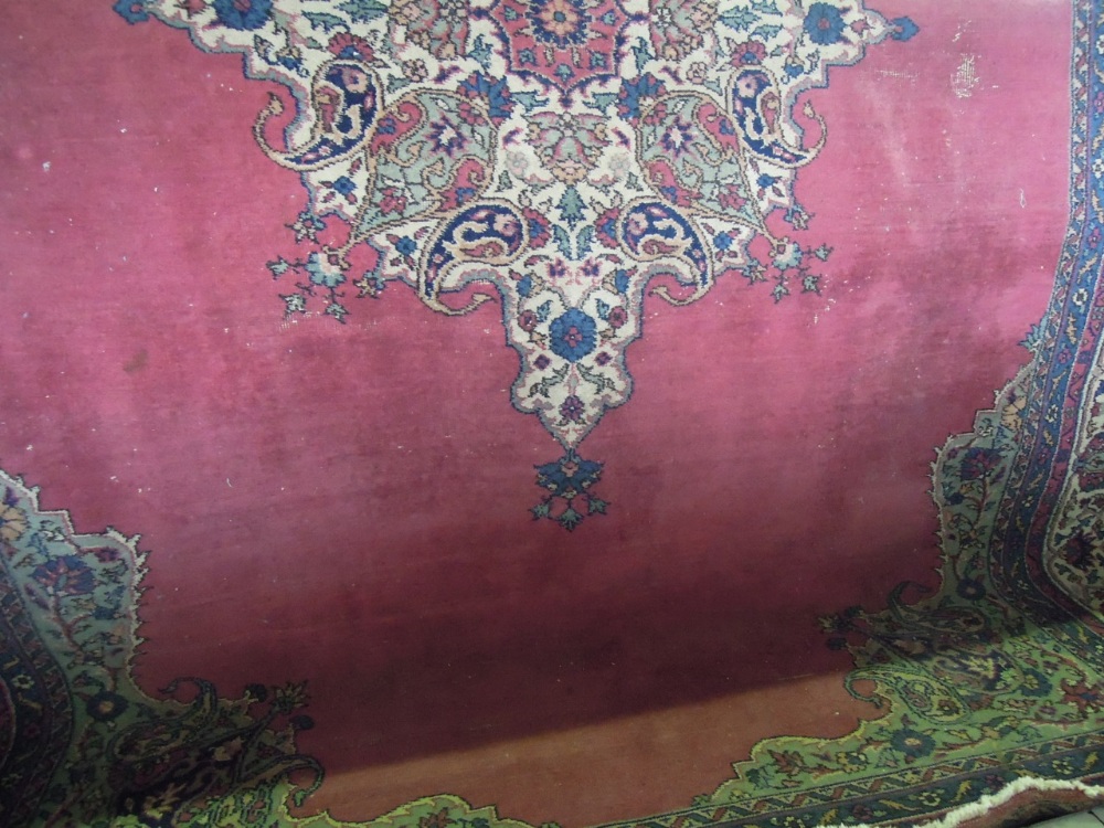 A Persian style carpet, the maroon ground field enclosing a geometric medallion centre within