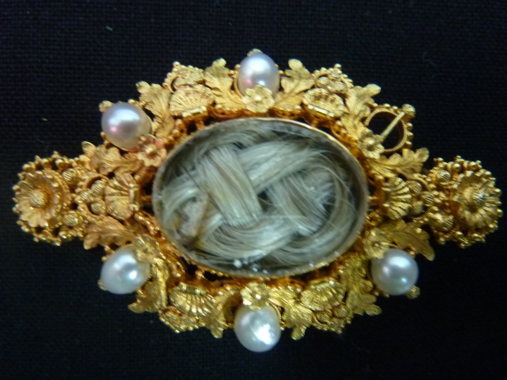 A 19th century pinchbeck memorial brooch, pearl set