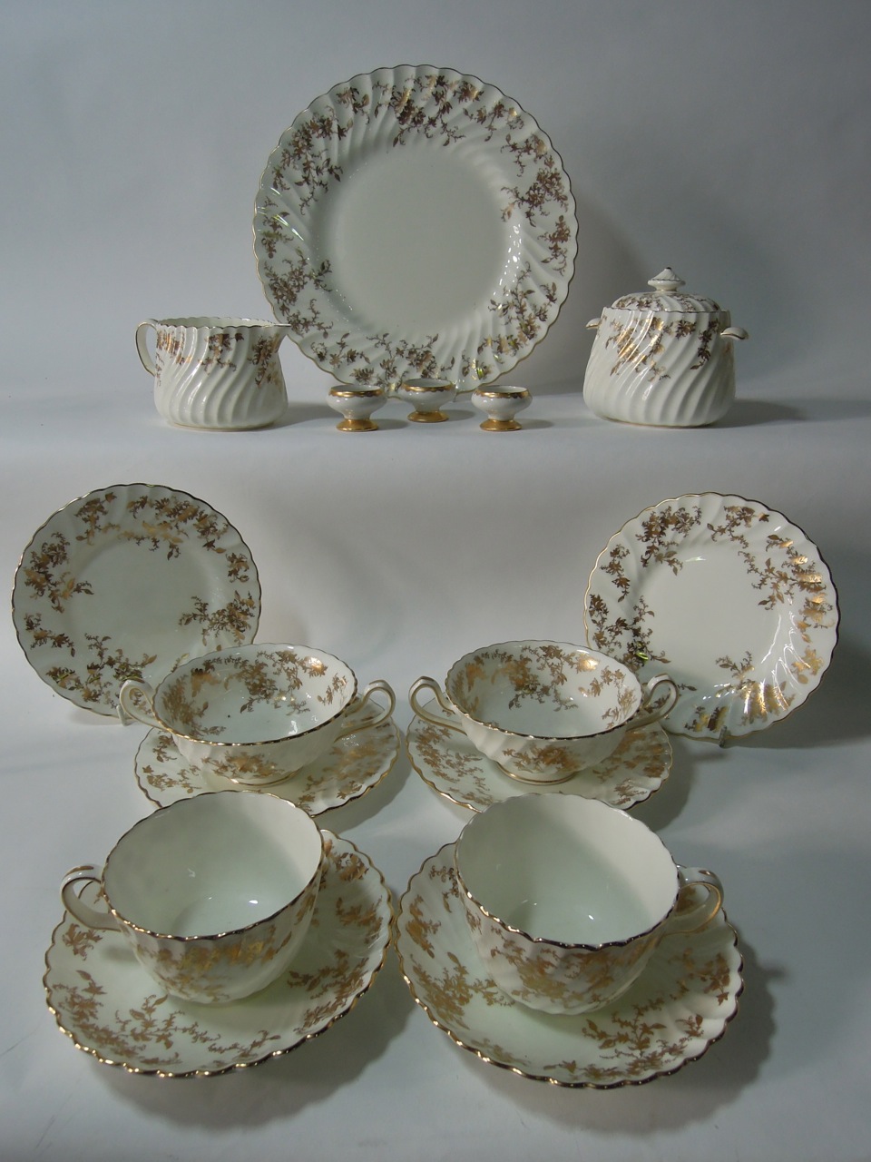 A quantity of Mintons "Ancestral" tea and dinner wares of fluted form with gilded floral