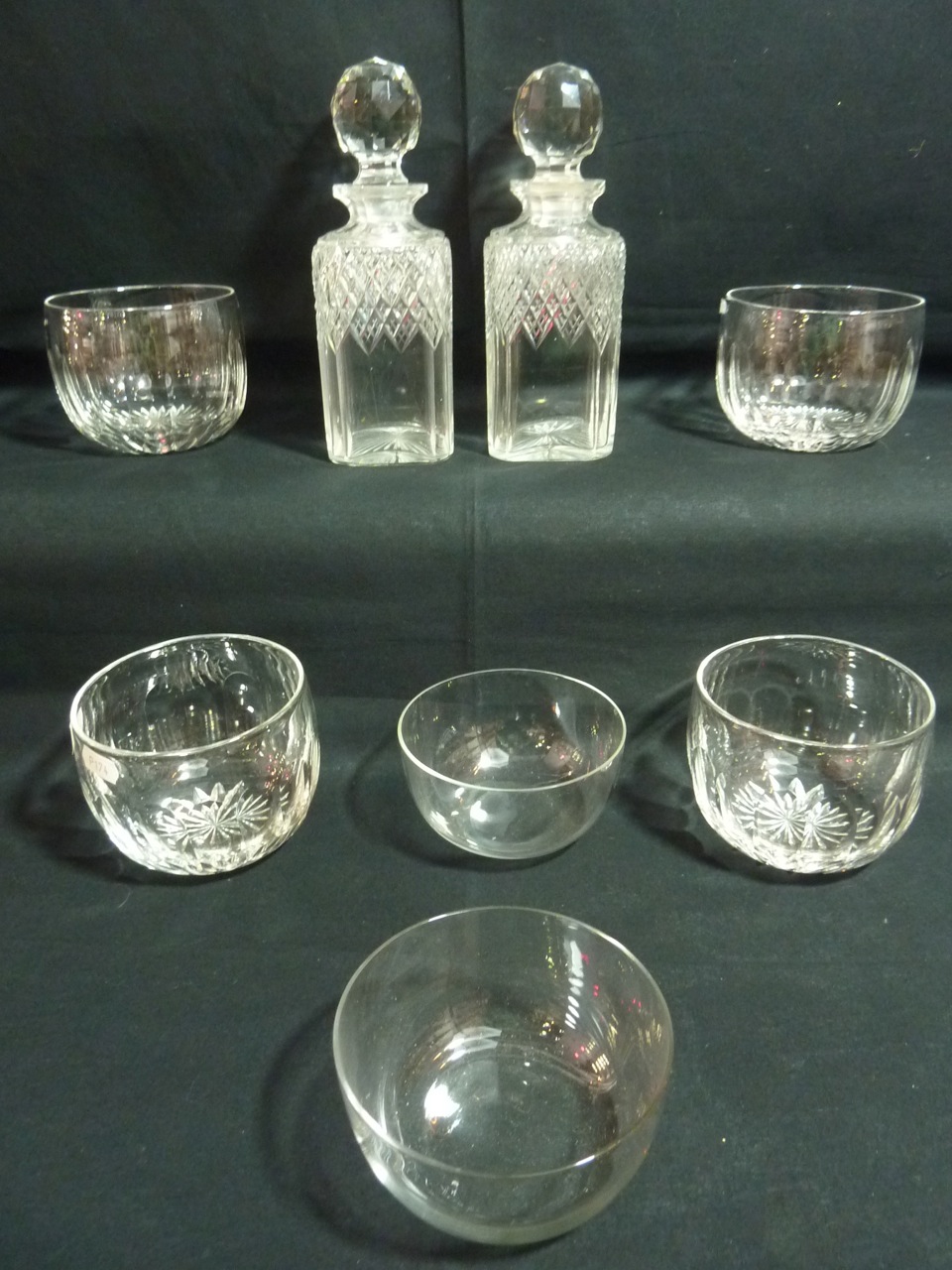 A pair of square form cut glass decanters with faceted globular stoppers, 23cm high approx