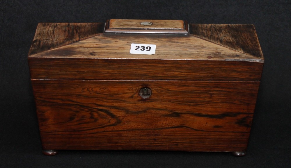 Mahogany tea caddy of sarcophagus form on pad feet, two lidded compartments and mixing bowl.