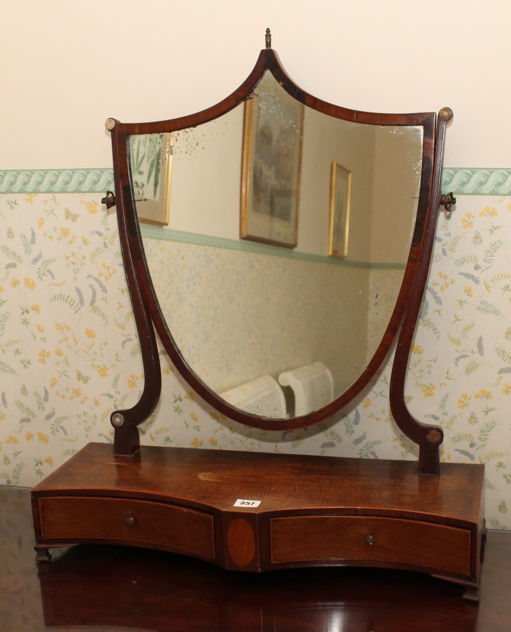 19th century mahogany inlaid shield-shaped dressing table mirror with drawers to the platform base.