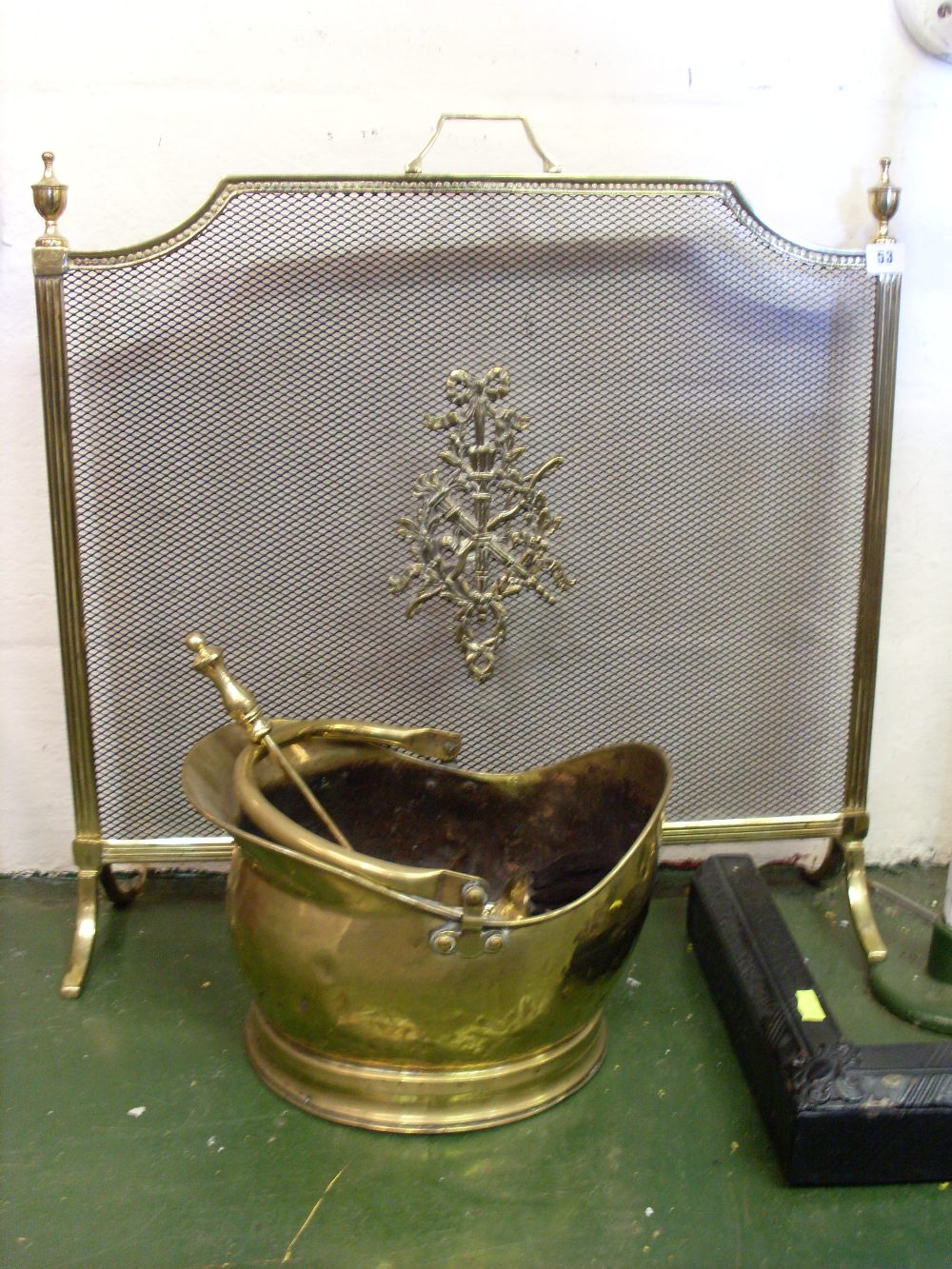 Gilt metal firescreen with mesh panel and a brass coal scuttle.