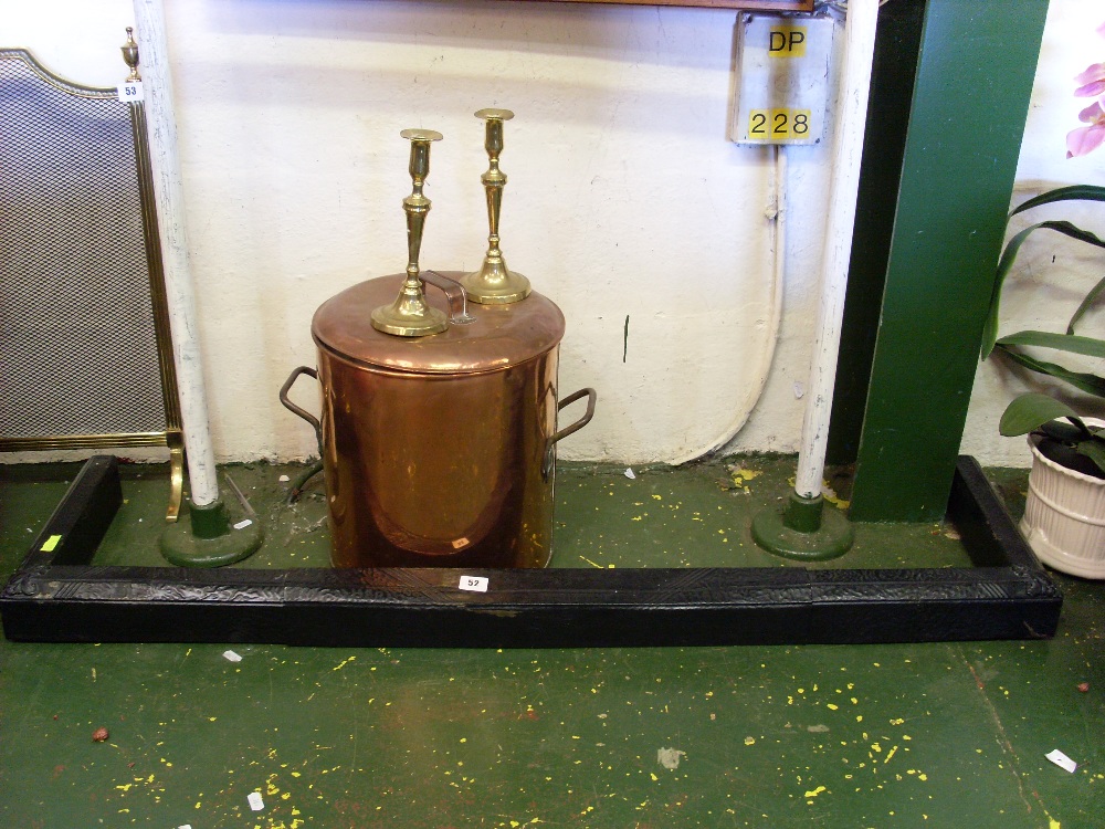 Copper coal bucket, a black metal fender and a pair of brass candlesticks.