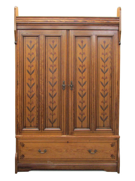 A 19th century Arts & Crafts pitch pine double wardrobe, the panelled doors painted with stylized