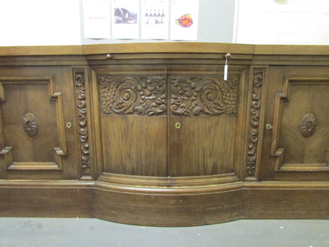 A 1930s German oak sideboard, the bow fronted centre section carved with stylized fruit, w. 245