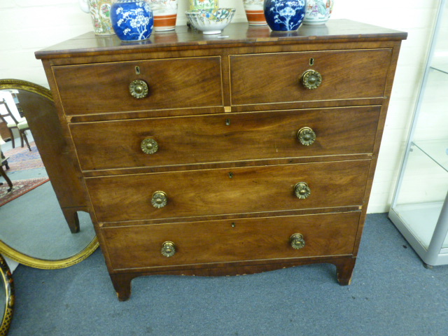 A George III mahogany chest of three graduated long and two short drawers with gilt metal handles on