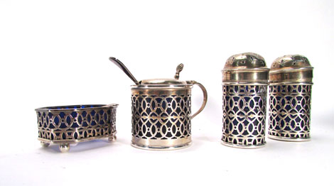 A silver five piece condiment set with pierced decoration, Birmingham hallmarks, together with a