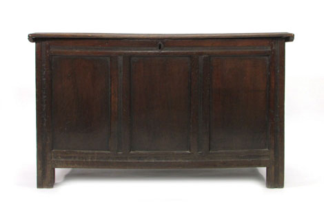 A 17th century panelled oak coffer with moulded plank top on stile supports, w. 124 cm CONDITION