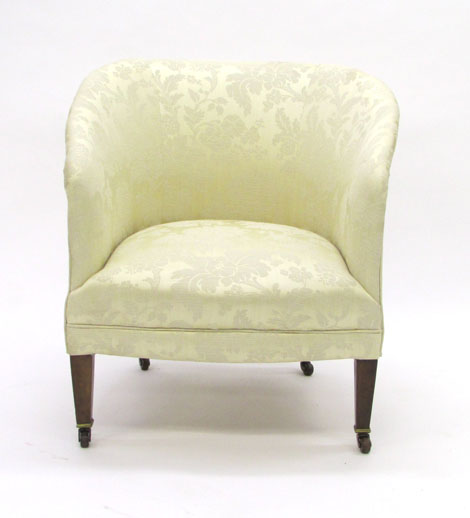 An Edwardian fully upholstered tub armchair covered in ivory damask on square tapered legs CONDITION