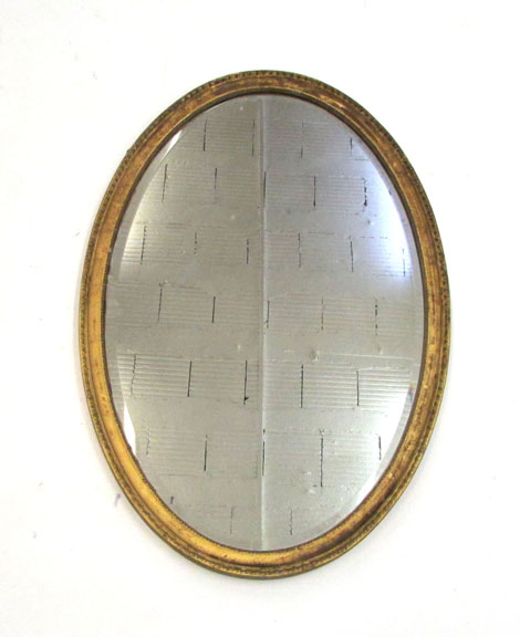 An 18th century-style wall mirror with oval bevelled plate in a moulded gilt frame, 50 x 90 cm