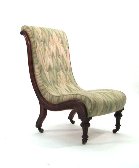 A Victorian walnut framed and button upholstered fireside chair of 'S' section on turned and