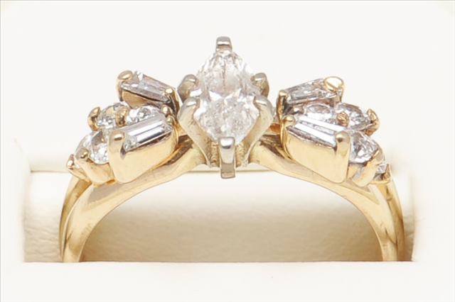 A MODERN DIAMOND RING. Comprising a claw set marquise central diamond ring estimated to weigh approx