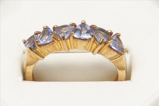 A SIX STONE TANZANITE HALF ETERNITY RING, in 9ct yellow gold, light coloured stones, trilliant in