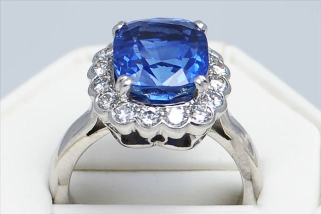 A FINE AND RARE CUSHION SHAPED CEYLONESE SHAPPHIRE, CORNFLOWER BLUE, AND DIAMOND CLUSTER RING,