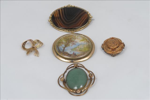 TWO OVAL BROOCHES SET IN UNHALLMARKED YELLOW METAL, one presumed tortoiseshell and secondly a