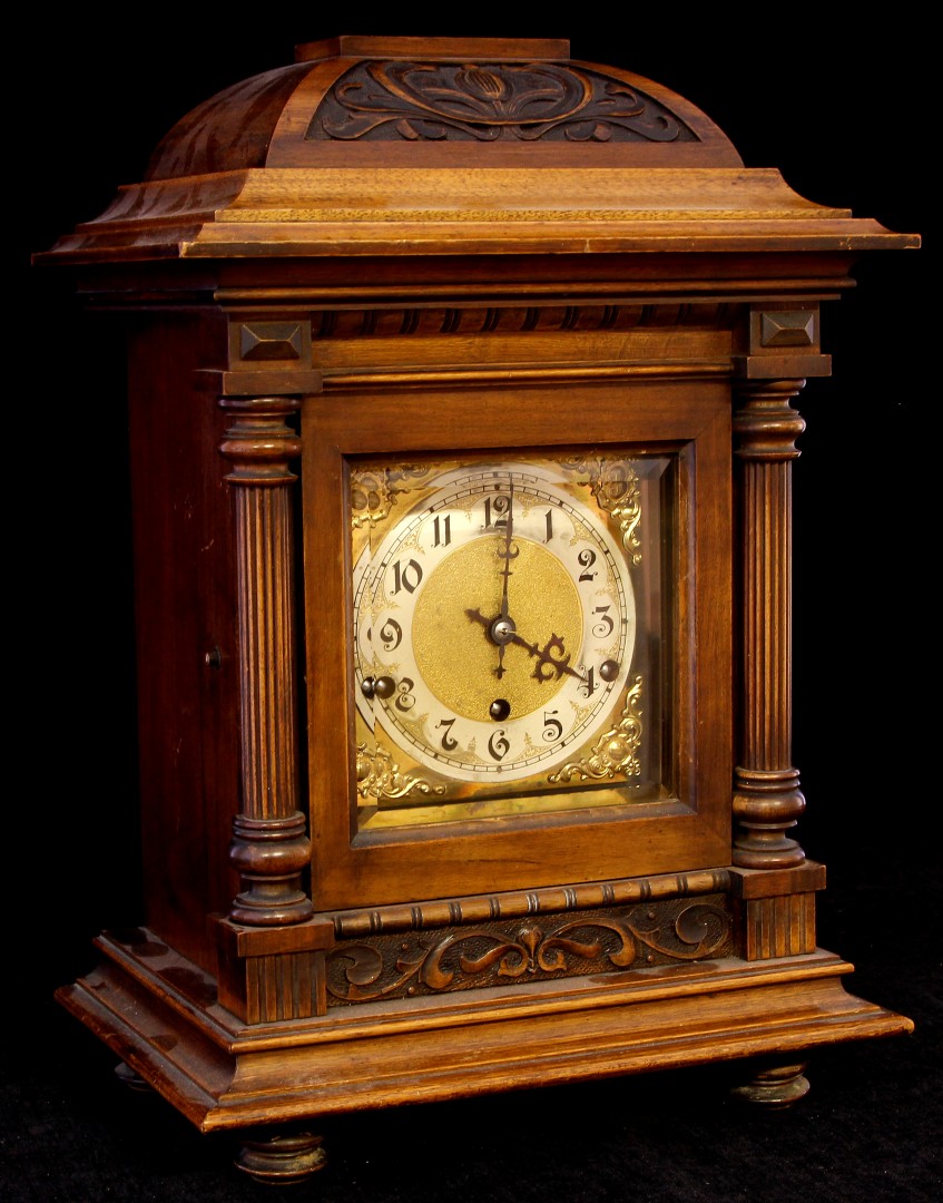 An early 20th century German Art Nouveau carved mahogany cased chiming mantel clock with silver