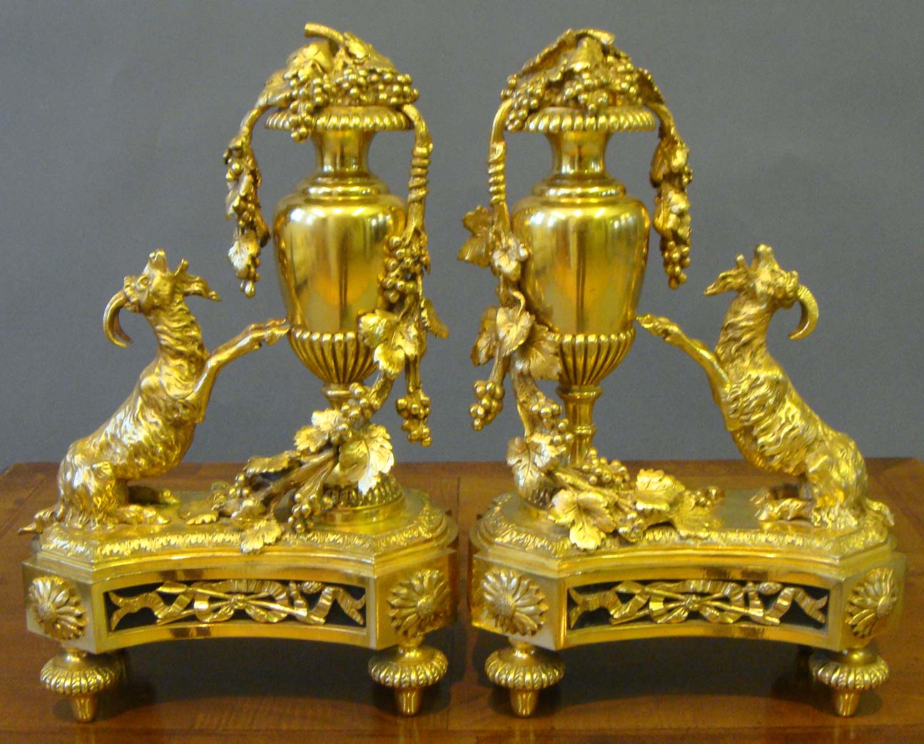 A pair of 19th century Louis XVI style Ormolu Chenets by Bouhon Freres, with shaped plinth bases and