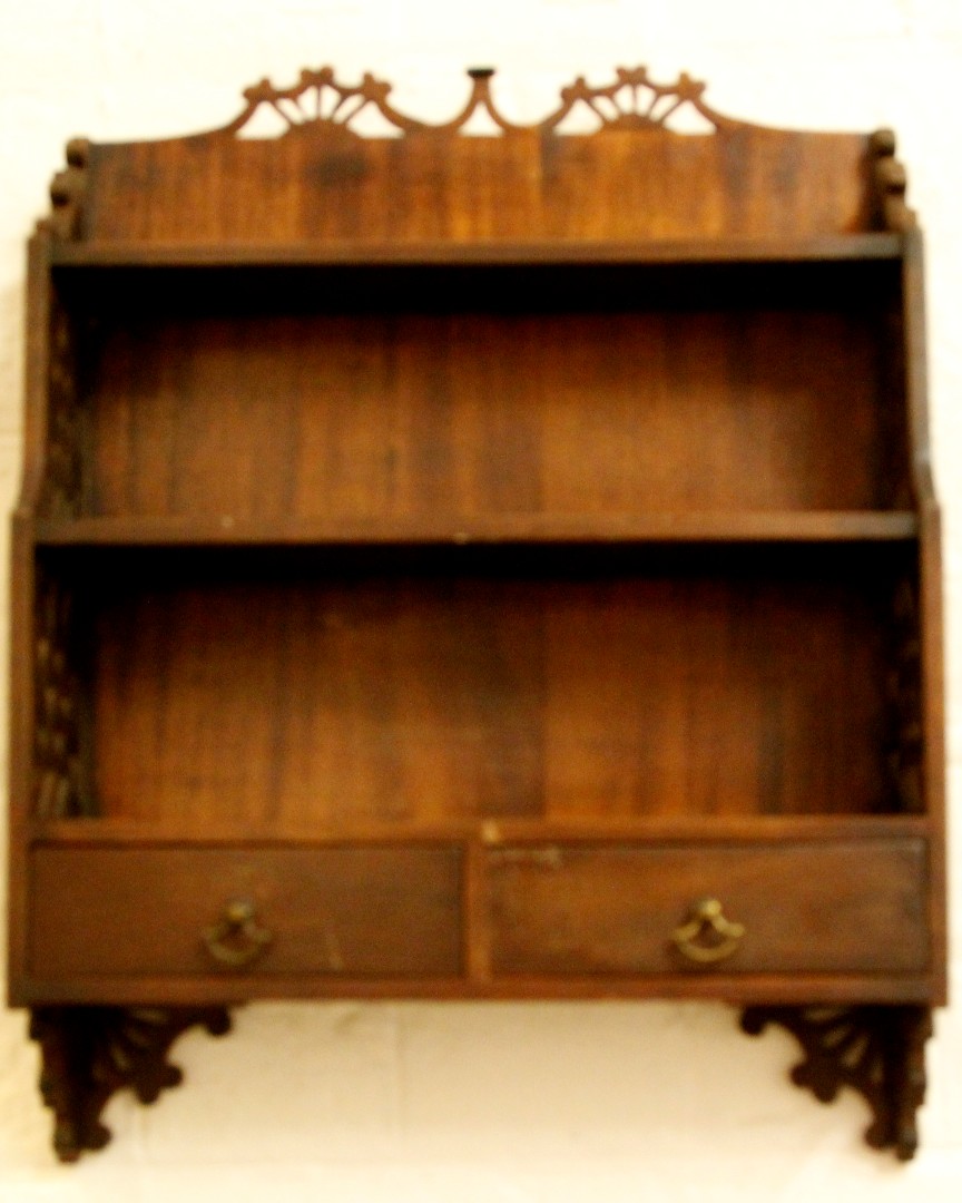 An early 20th century mahogany two tier wall shelf with pierced sides and top, the two shelves above